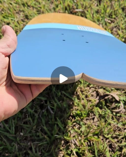 Hand holding deck showing concave profile — blue graphic