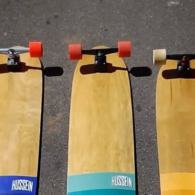 Three longboards side by side — red and white wheels