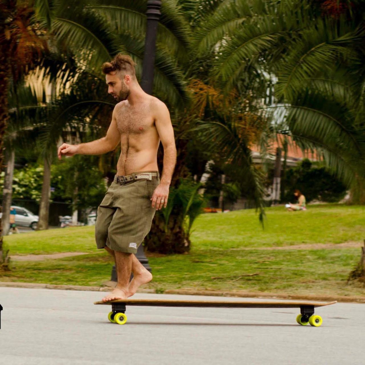 Rider descalço no longboard Hussein — palmeiras e vibe tropical