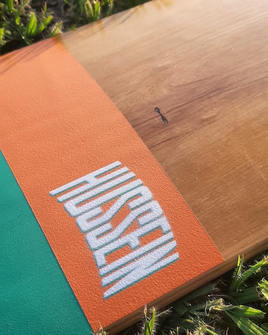 Shape Hussein com logo laranja sobre a grama