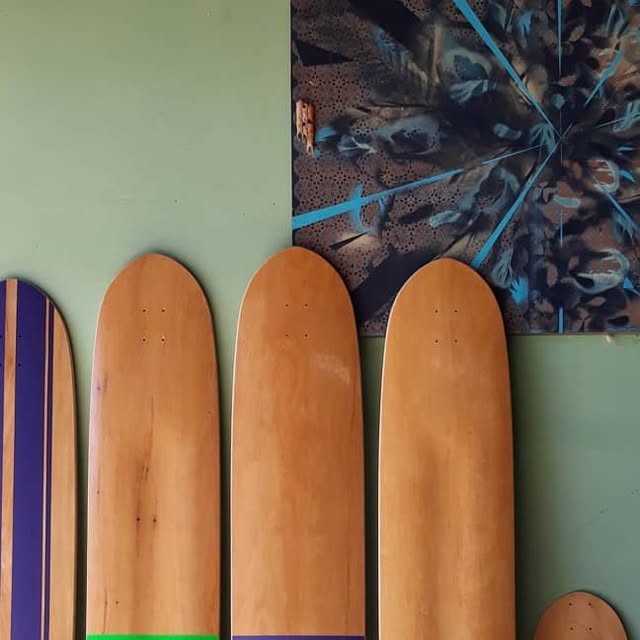 Blank skateboard decks against green wall