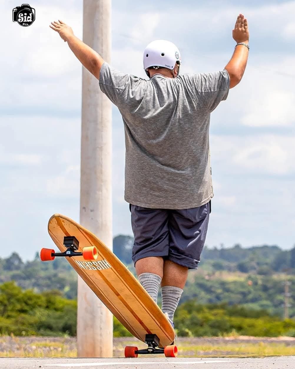Skatista com capacete descendo ladeira